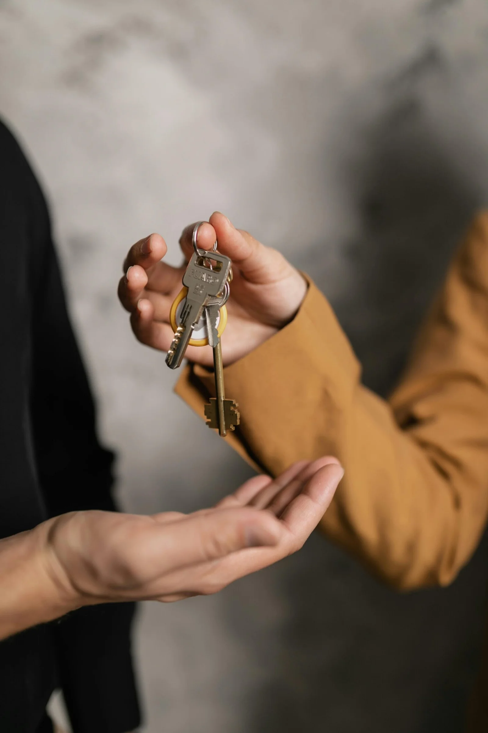 Person handing over property keys for property maintenance services in Tirana and Durres